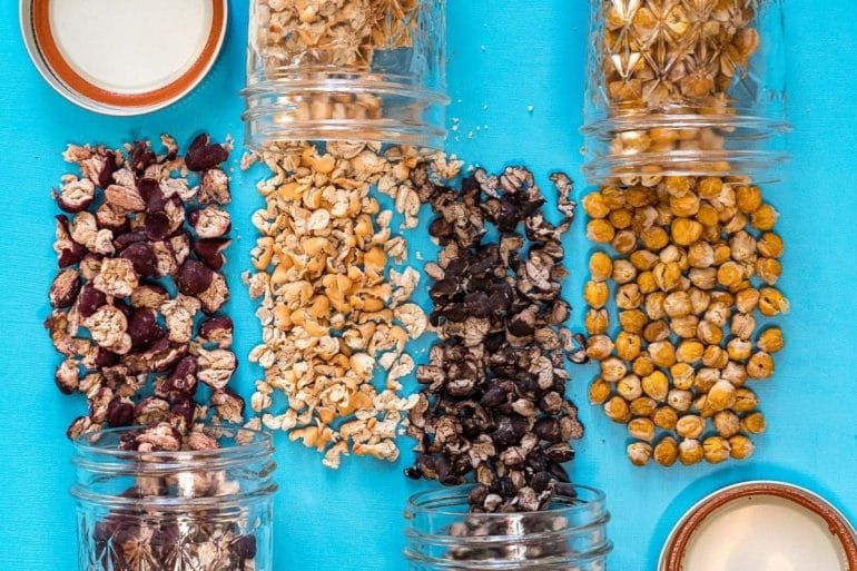 Different types of dehydrated beans spilled out over a blue background