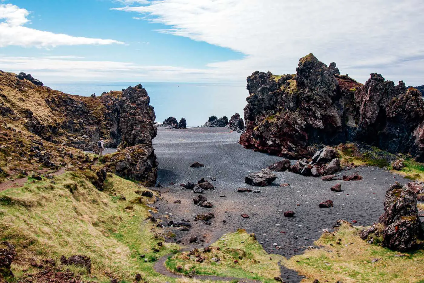 A black sand beach with volcanic rock formations