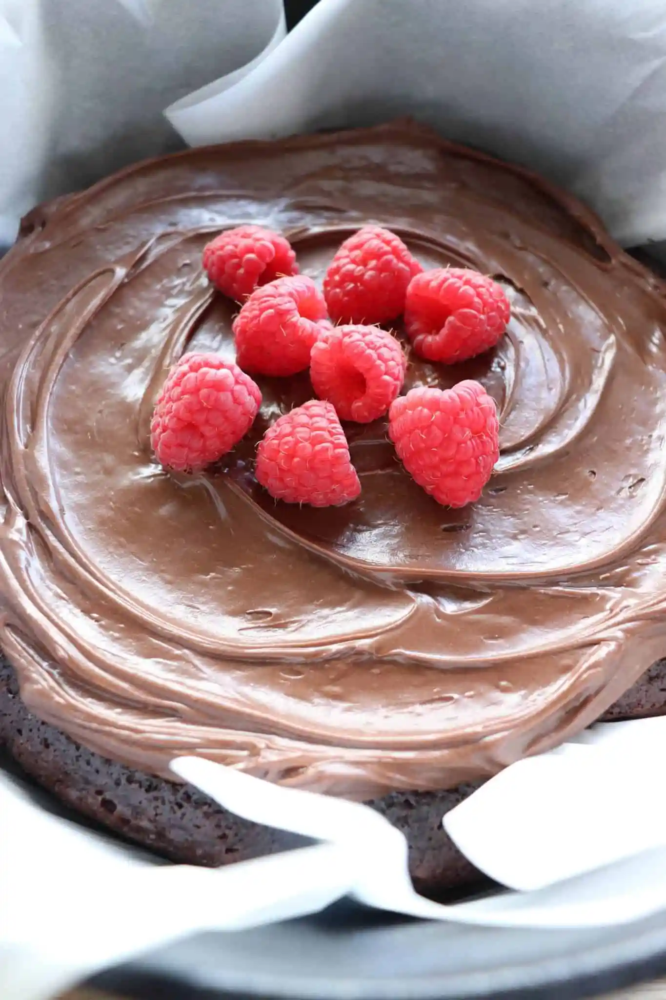 Chocolate cake topped with whole raspberries.
