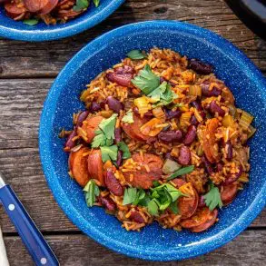 A blue bowl of red beans and rice on a natural surface