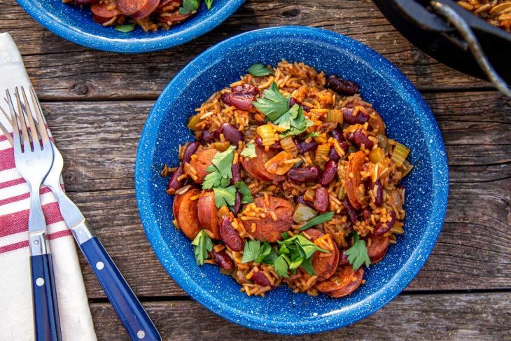 A blue bowl of red beans and rice on a natural surface