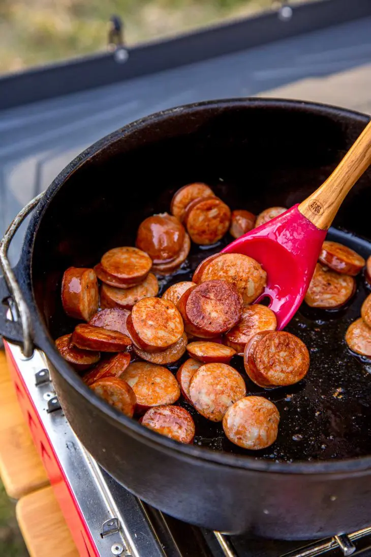 Sliced sausage browning in a Dutch oven