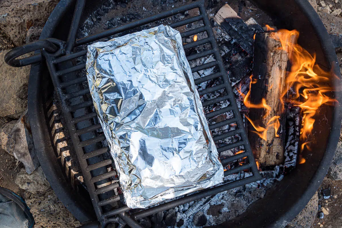 A foil packet over a campfire