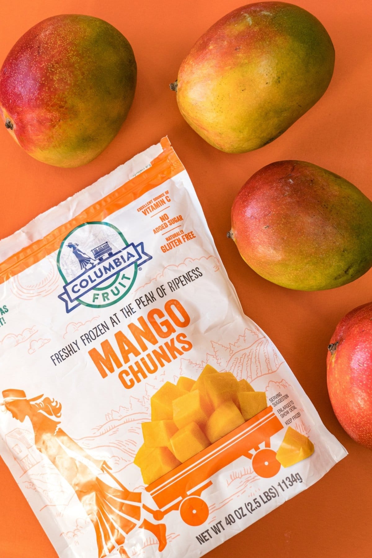 Fresh mangoes next to a bag of frozen mango