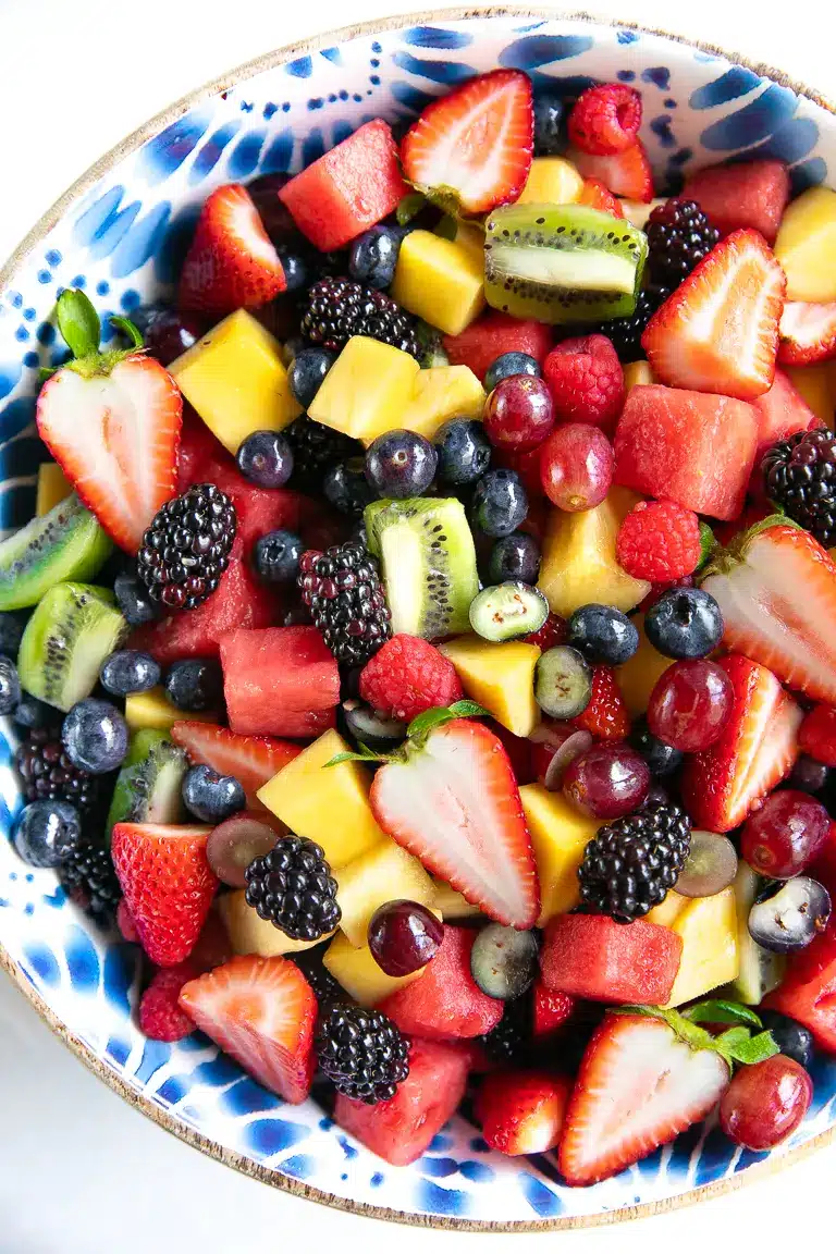 Fruit salad with berries, grapes, kiwi, and pineapple in a bowl.