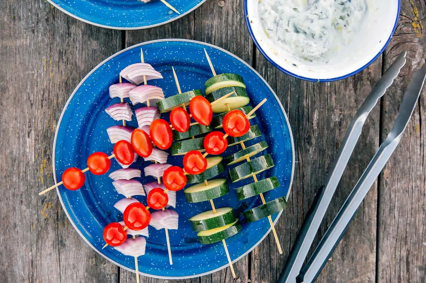 Tomatoes, red onion, and zucchini on skewers