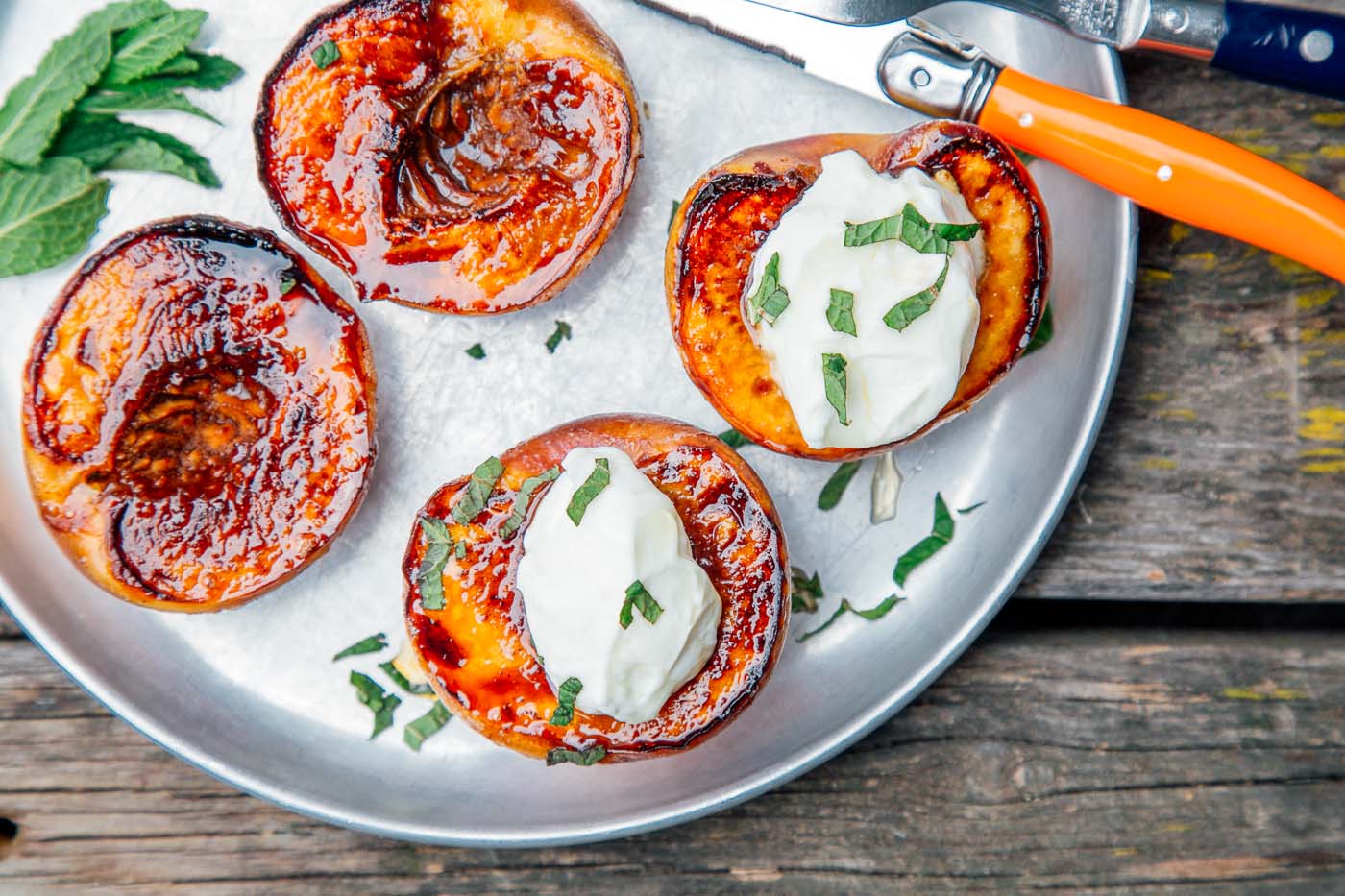 Grilled peaches with yogurt on a silver plate