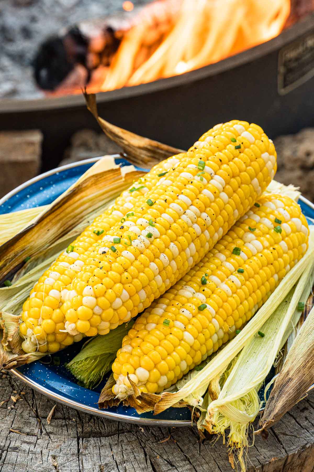 Grilled corn on the cob stacked on a plate