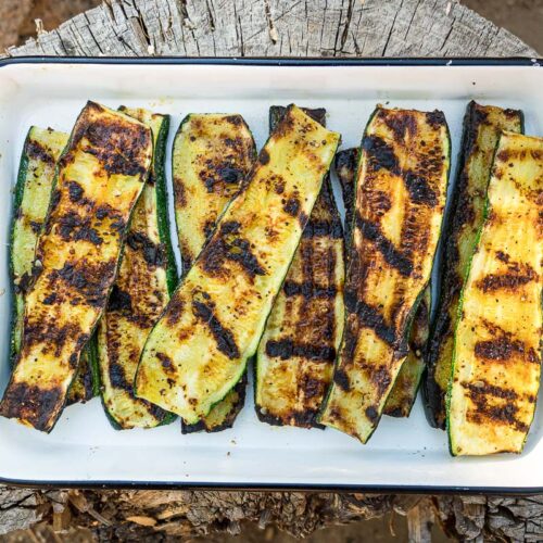 Grilled zucchini in a white enamel dish