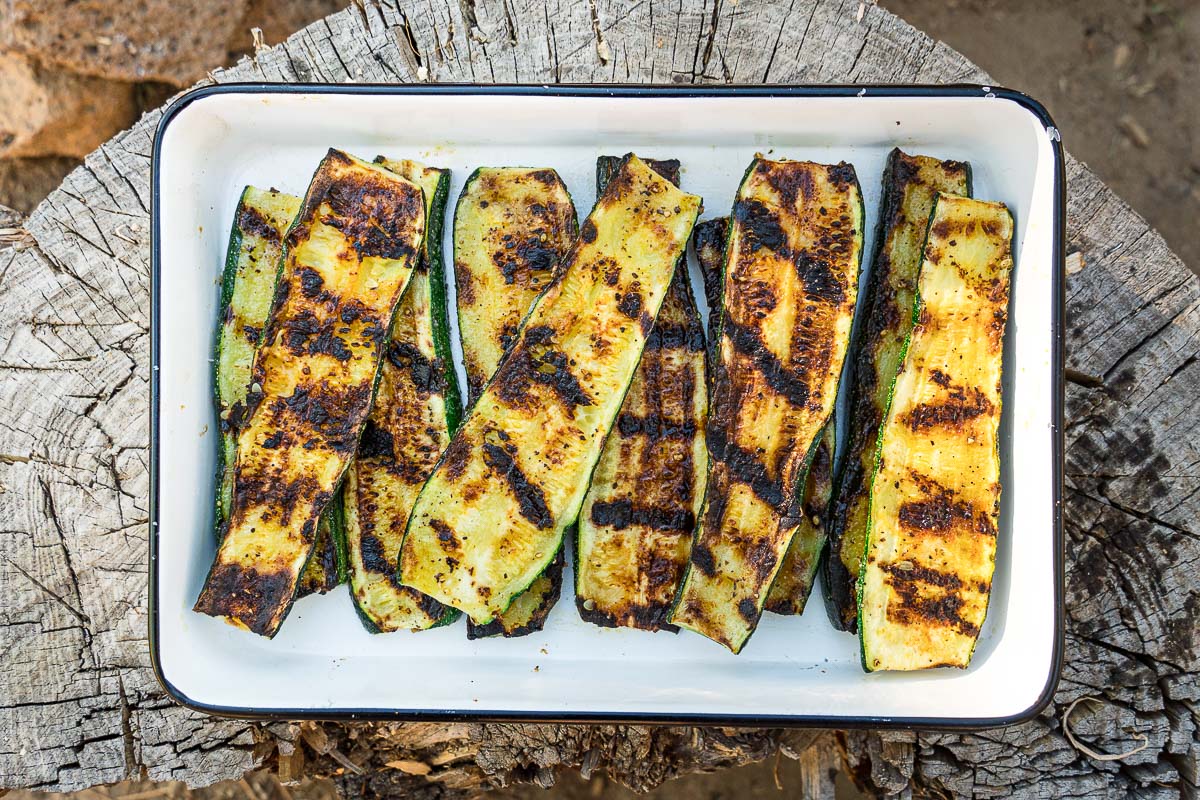 Grilled zucchini in a white enamel dish