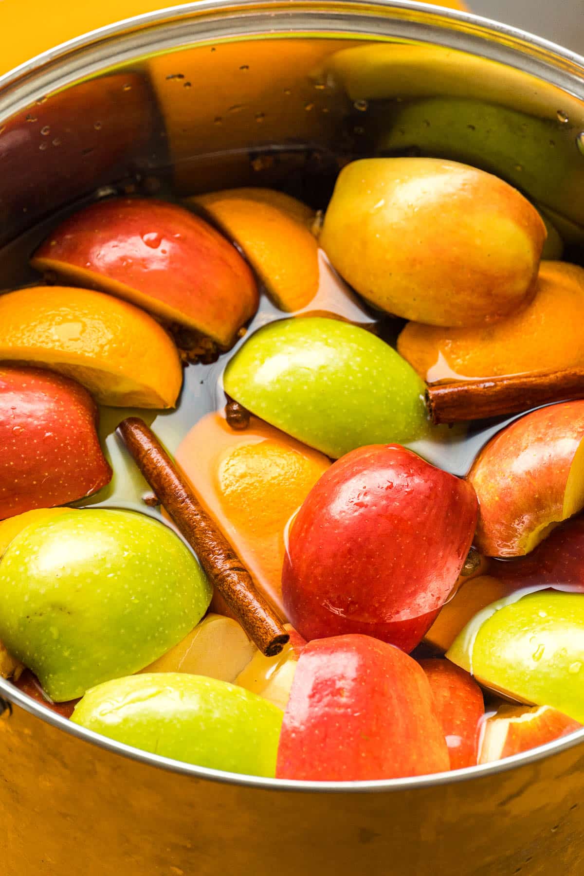 Apples, oranges, and spices in a large stock pot.