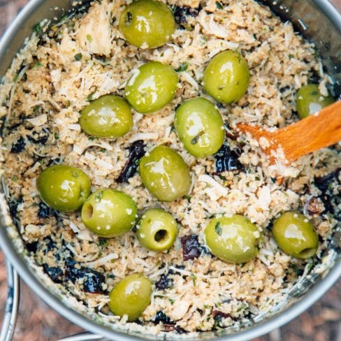 A pot with couscous, chicken, and green olives