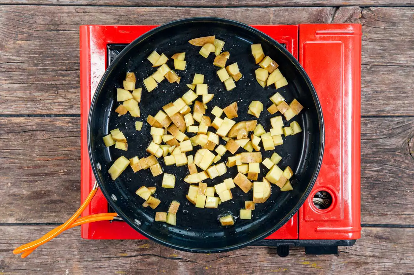 Cubed potatoes in a skillet for a breakfast scramble