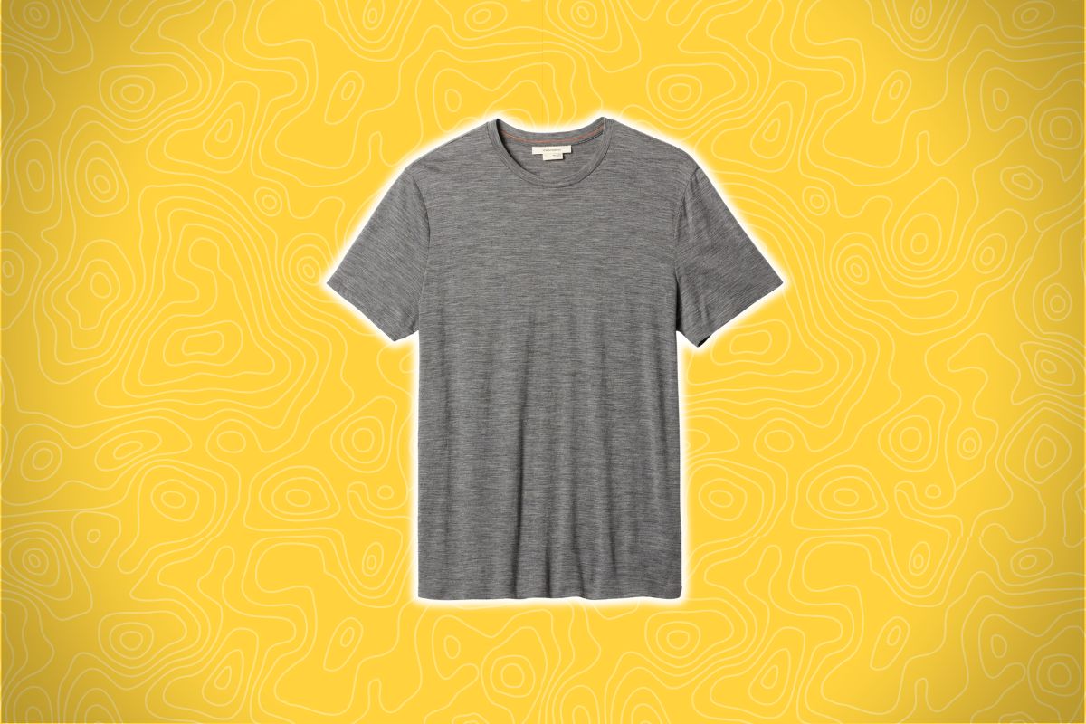 A gray short-sleeve T-shirt sits on a bright yellow background with abstract wavy line patterns.
