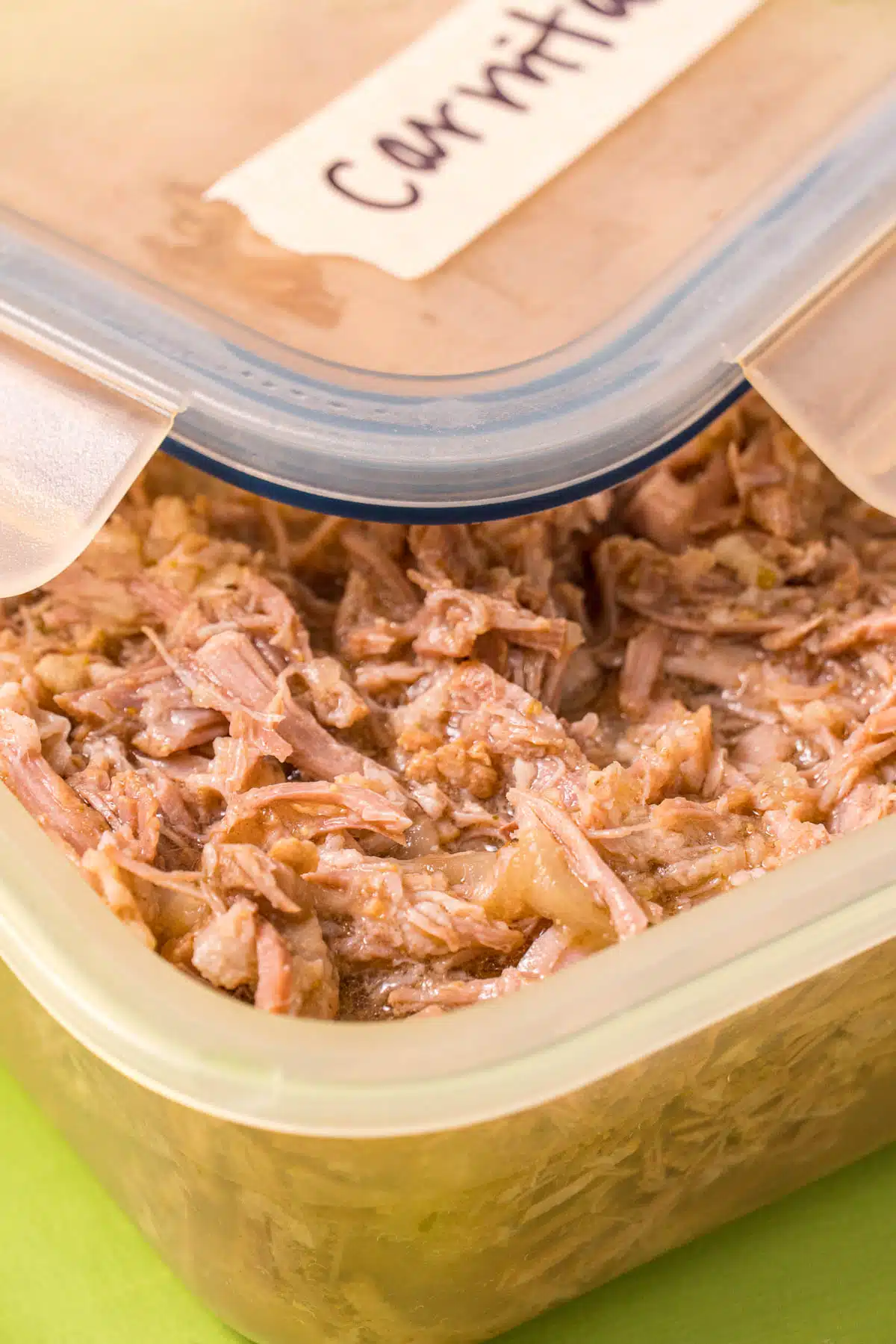 Cooked carnitas in a storage container.