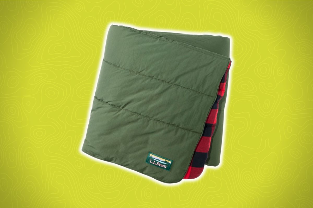 A neatly folded green outdoor blanket with a red and black plaid interior and an L.L.Bean patch on a yellow background.