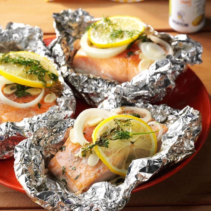 Salmon topped with lemon slices and dill, served in foil.