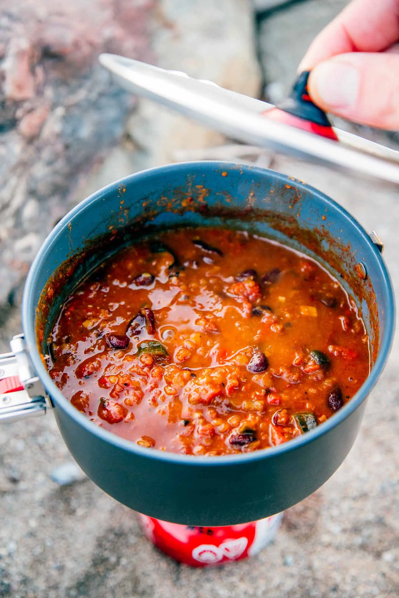 A backpacking pot full of red lentil chili.