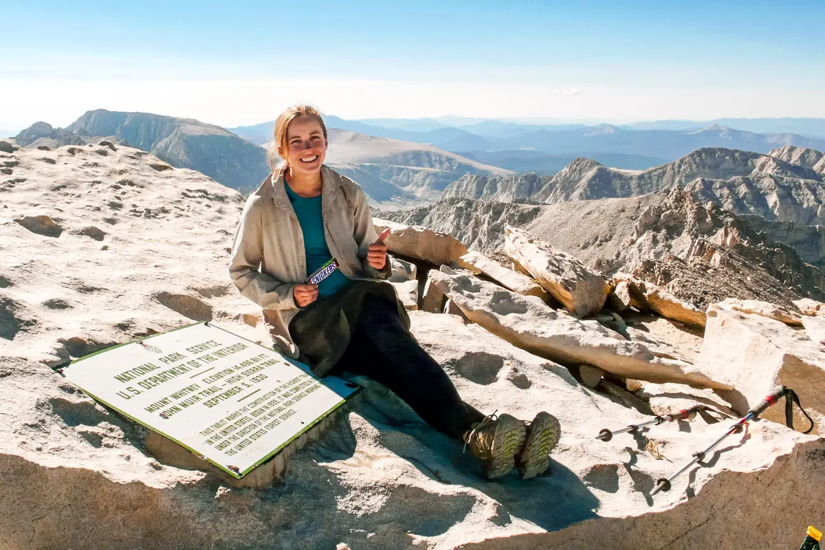 Megan holding a Snickers bar on the summit of Mt. Whitney