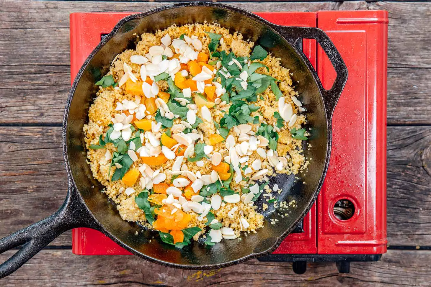 Couscous with apricots, almonds, and parsley in a cast iron skillet