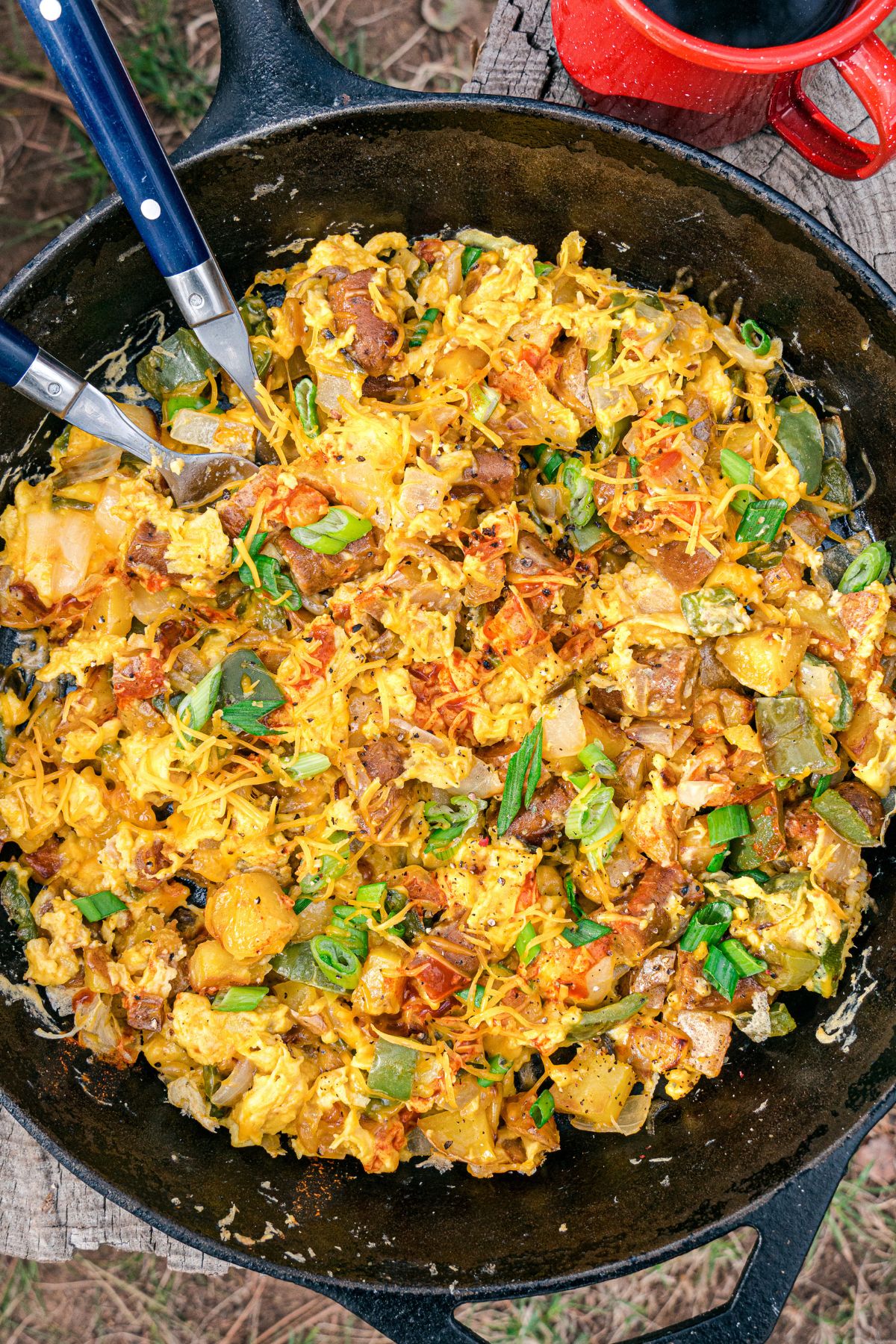 Cheesy scrambled eggs and potatoes in a cast iron skillet