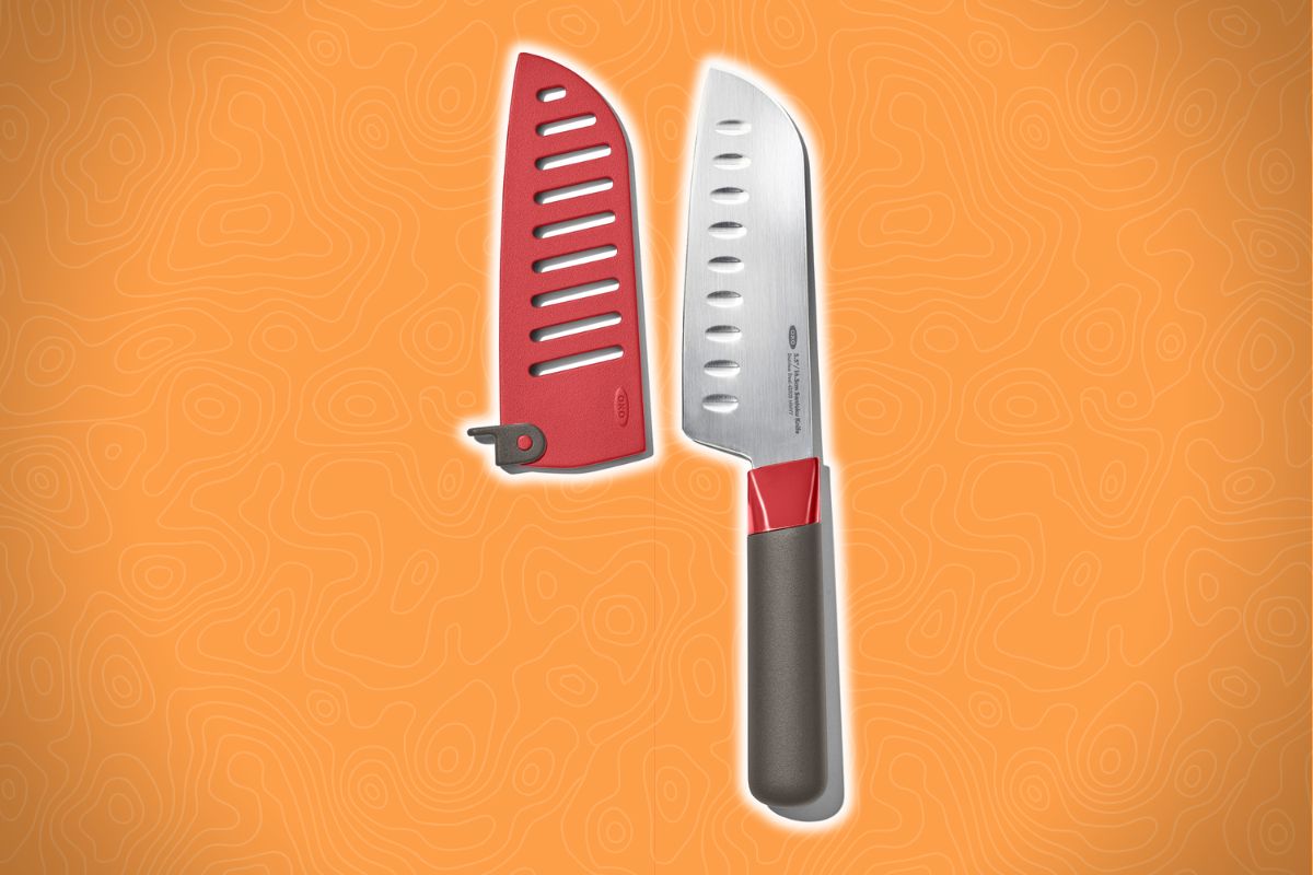 A kitchen knife with a gray handle and silver blade lies beside a red blade cover with angled slits and a latch on an orange background.