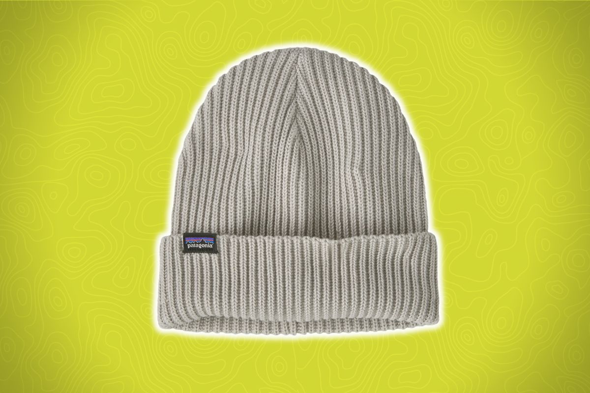 A light gray ribbed knit beanie with a folded brim and small rectangular Patagonia logo tag on a yellow background.