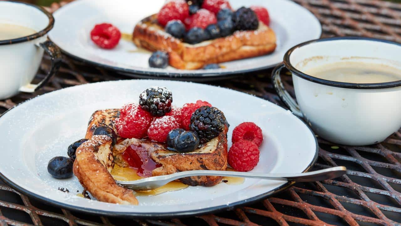 French toast with berries on a camping plate.