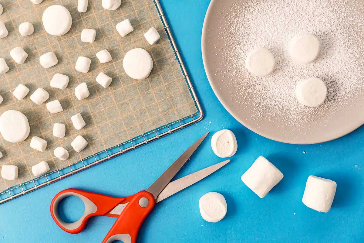 Cutting marshmallows in half to put on a dehydrator try