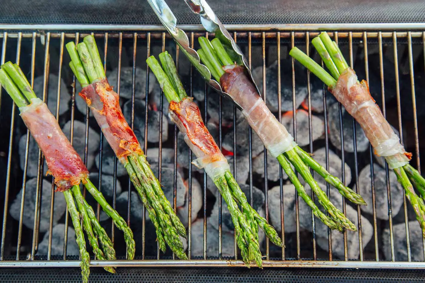 Prosciutto wrapped asparagus bundles on a grill