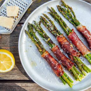 Prosciutto wrapped asparagus bundles on a plate