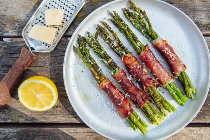 Prosciutto wrapped asparagus bundles on a plate