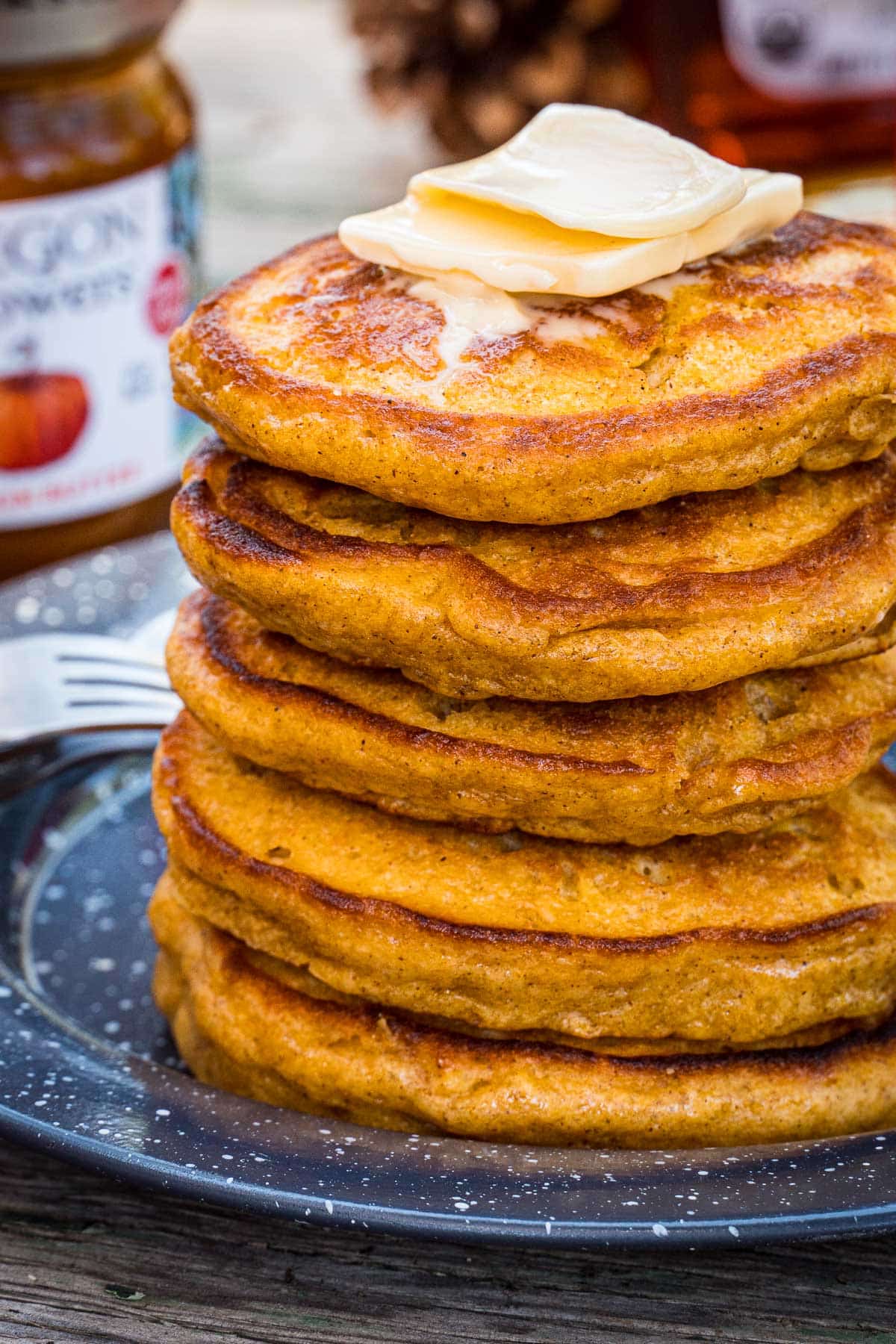 A stack of pumpkin pancakes topped with butter.