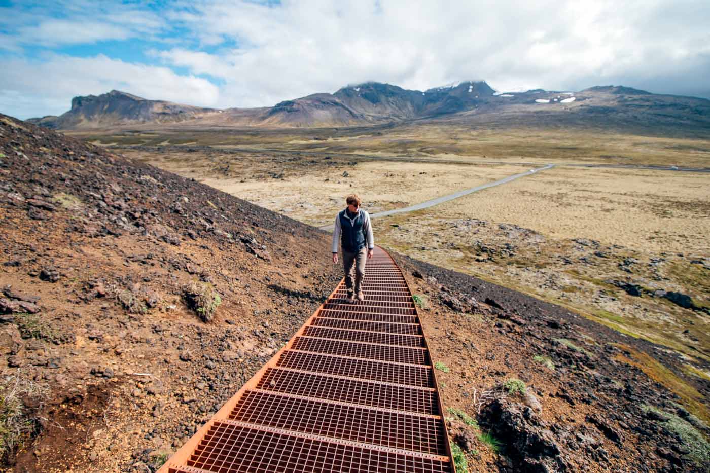 Michael walking down metal stairs on the side of the Saxholl Crater