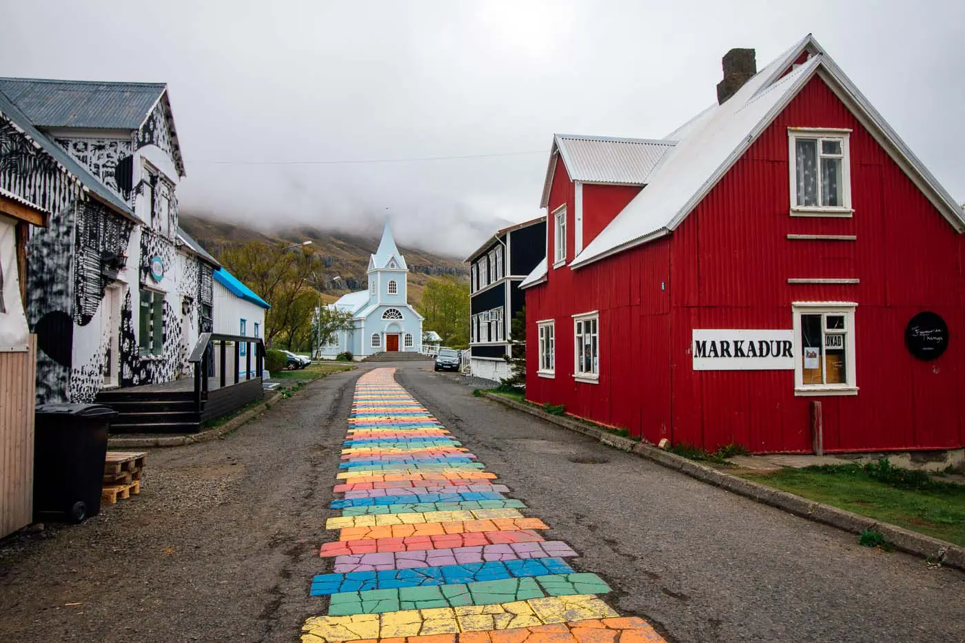 Painted rainbow road leading to a blue church
