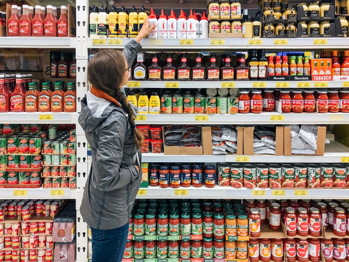Woman selecting a bottle off a shelf at a Bonus grocery store