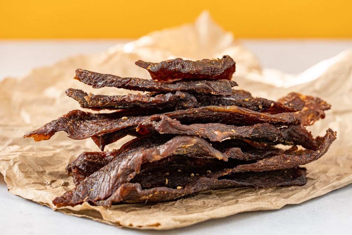 Beef jerky stacked on a piece of parchment paper