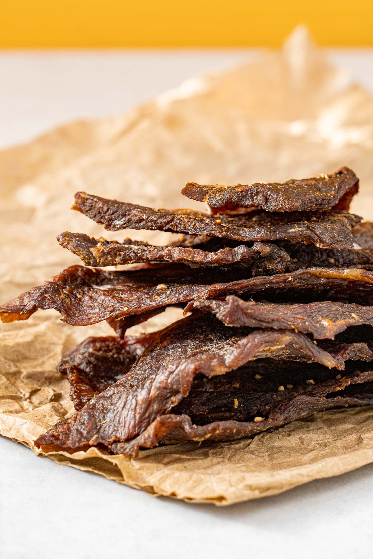 Beef jerky stacked on a piece of parchment paper