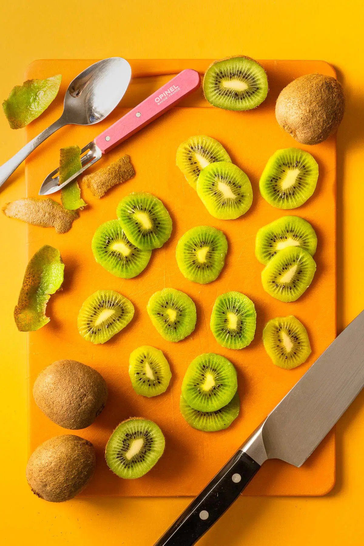 Slices of kiwi arranged on an orange surface