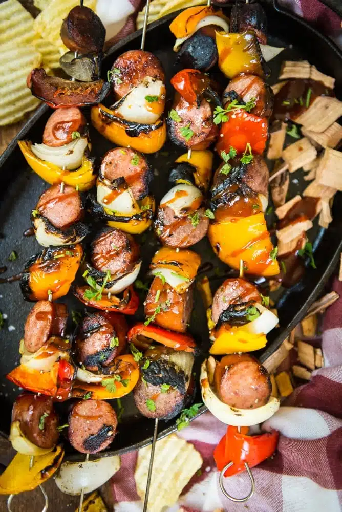 Grilled skewers with a delicious mix of sausages, bell peppers, onions, and mushrooms, perfect for a flavorful and colorful barbecue feast.