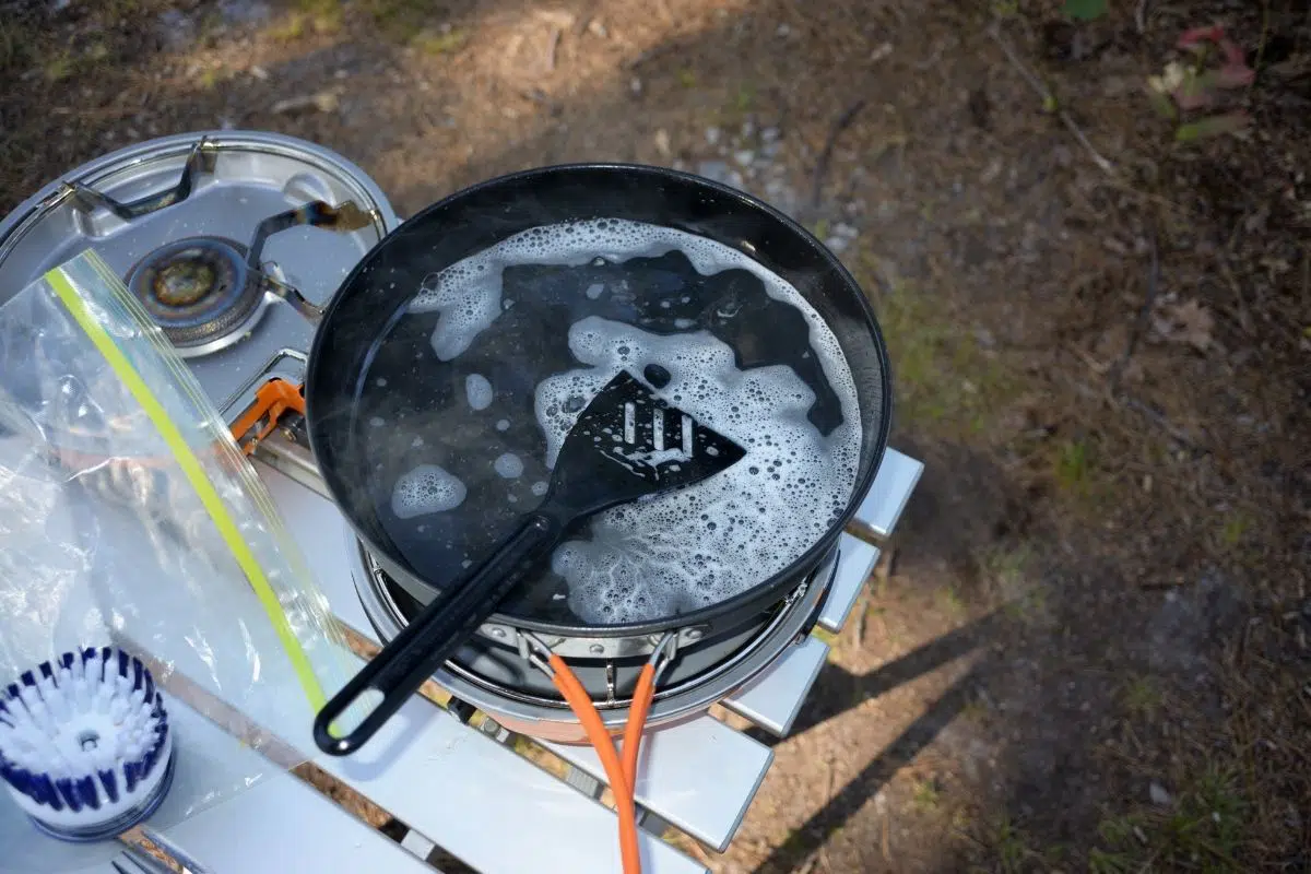 A camp skillet filled with soapy water on a table
