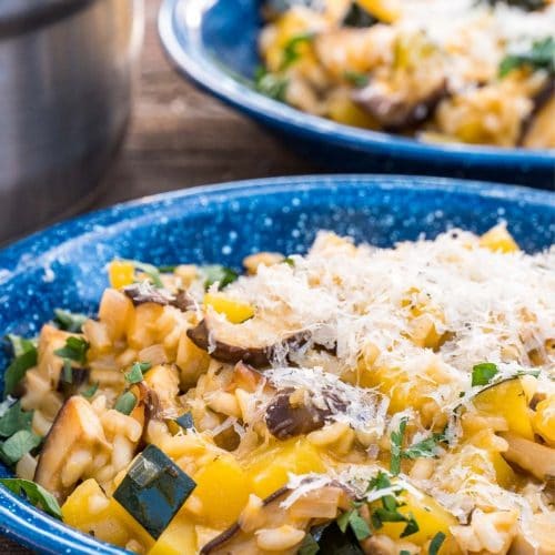 A blue bowl filled with acorn squash and mushroom risotto