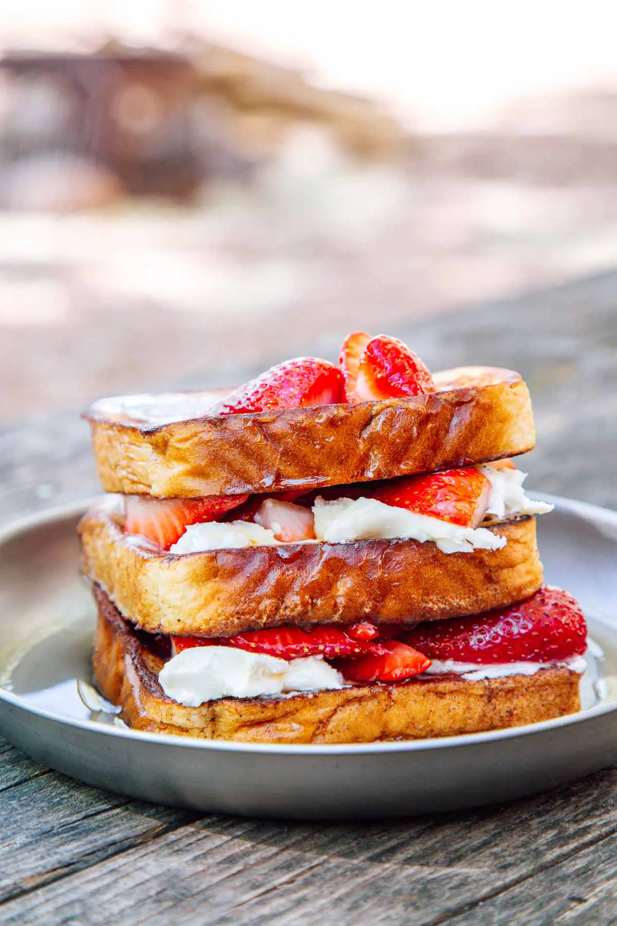 Stuffed french toast topped with strawberries on a camping plate