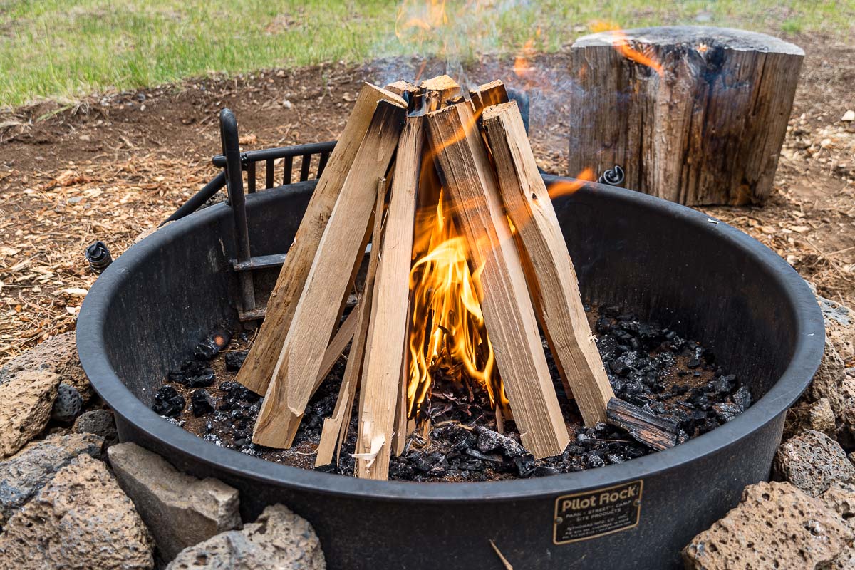 Wood logs arranged in a teepee campfire formation