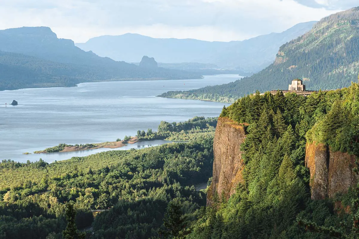 A view down the Columbia River Gorge. The Vista House sits on a rocky bluff.