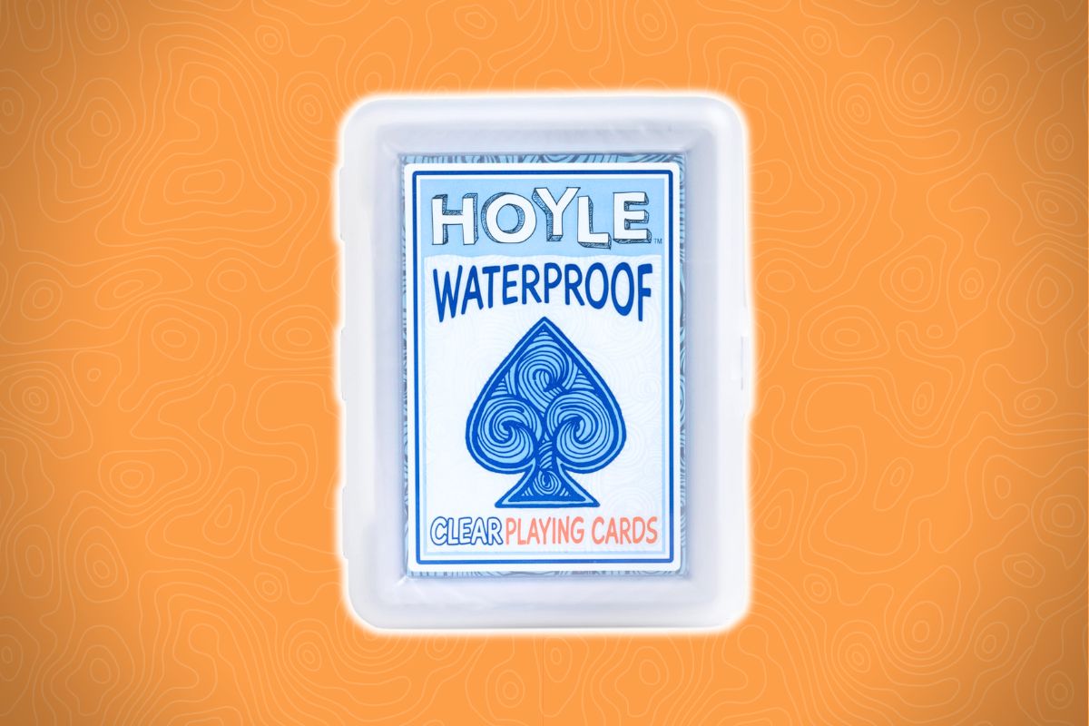 Hoyle waterproof clear playing cards in a see-through plastic case on an orange background with wavy lines.