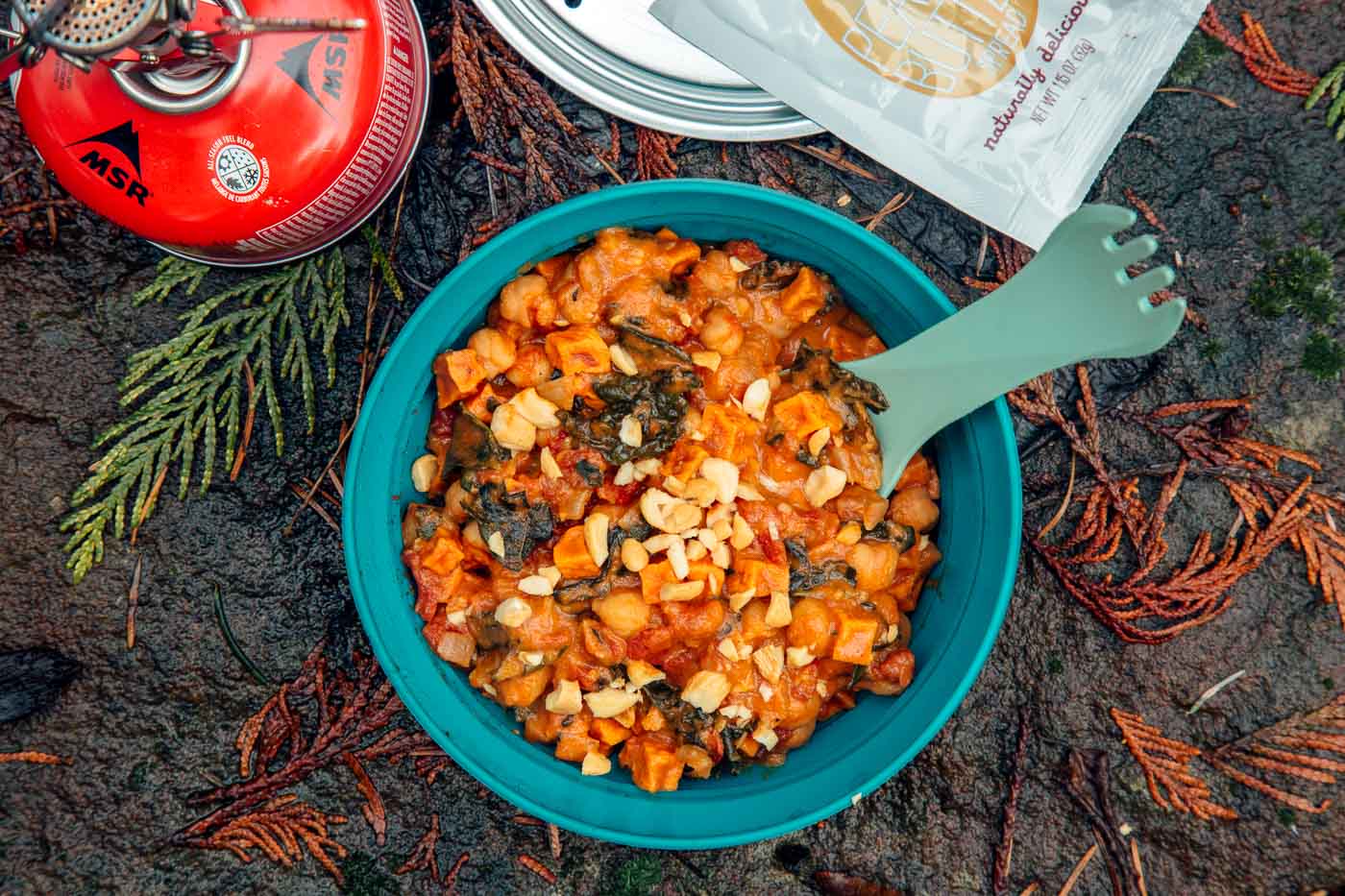 A blue bowl of sweet potato stew on a natural background