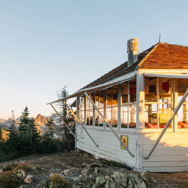 The Winchester Mountain Lookout Tower with mountain peaks in the distance.