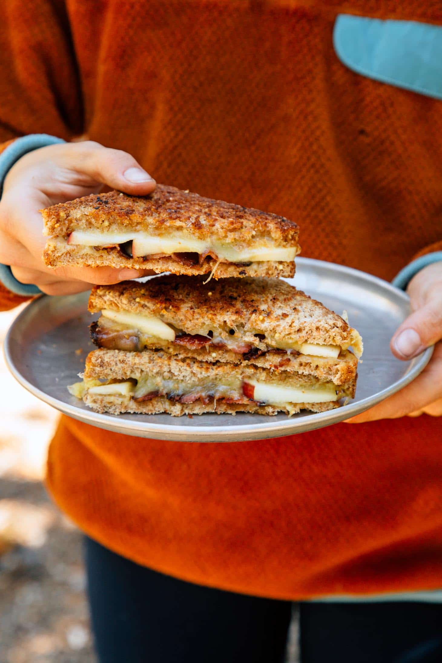 Holding an apple cheddar grilled cheese sandwich.