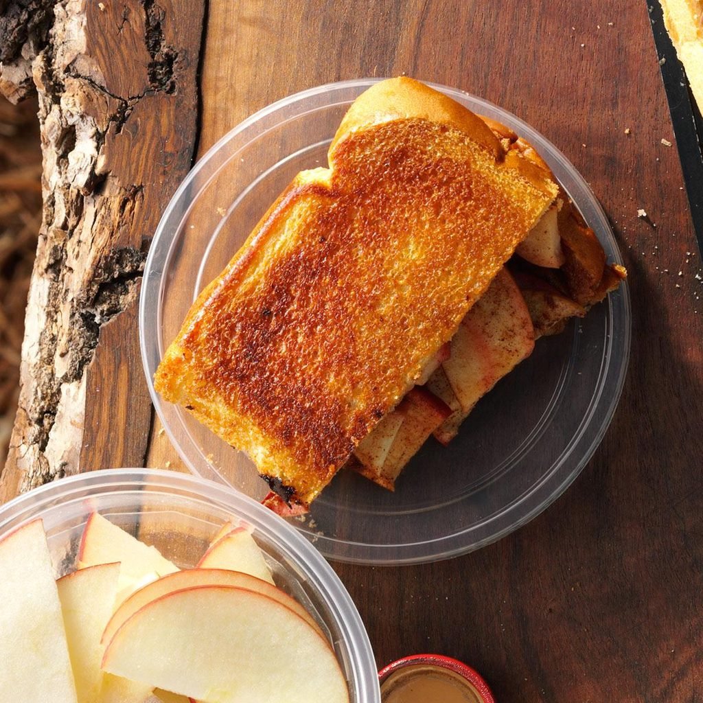 Toasted bread with apples on a wooden surface.